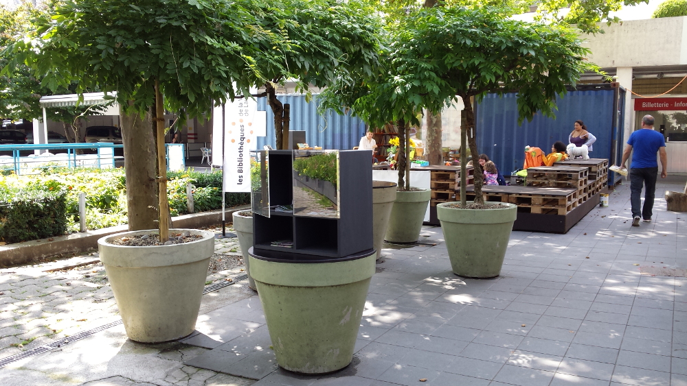 A panorama of the public library container and the reading possibilities in front of it. The small box in the front contains information for free use.