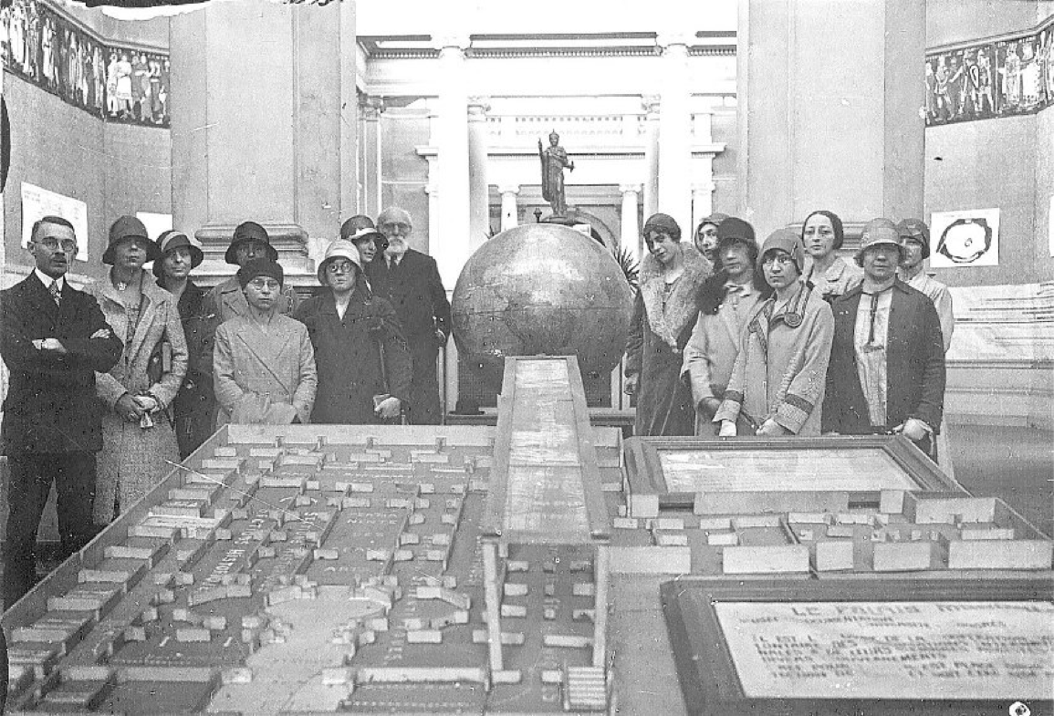Paul Otlet und Mitarbeiterinnen mit einem Modell der Weltstadt des Wissens (im Palais de Cinquentanaire, Brüssl, ca. 1910) - Quelle (c) Mundaneum Mons, Belgien.
